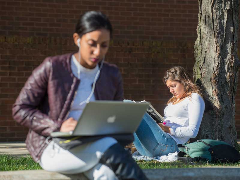 two v.c.u. students studying outside on a sunny day