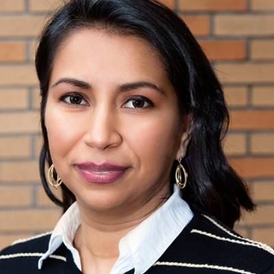 Alicia Borre, Ph.D., in front of a brick wall