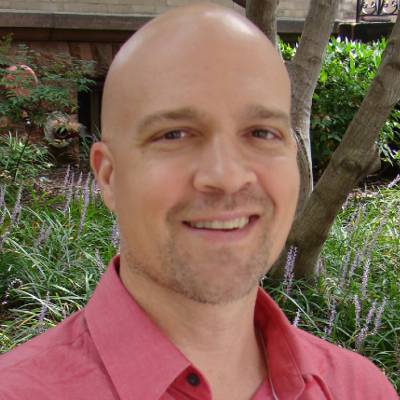 Kurt Crandall, Ph.D., in front of greenery