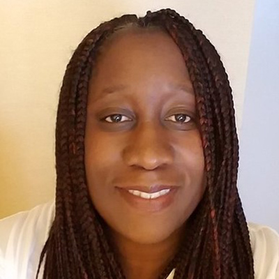 Vivian Dzokoto, Ph.D., in front of a white screen